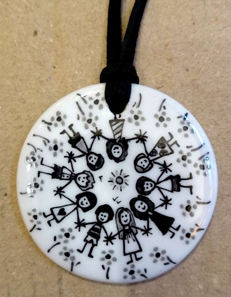 Pendentif rond en porcelaine personnalisé par une frise d'enfants en noir et gris